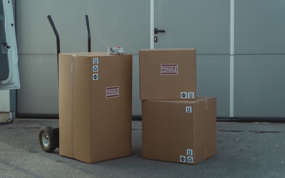 Cases stacked beside a hand truck on a loading floor