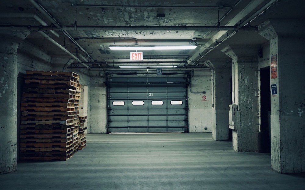 An empty loading bay with pallets stacked at the far end